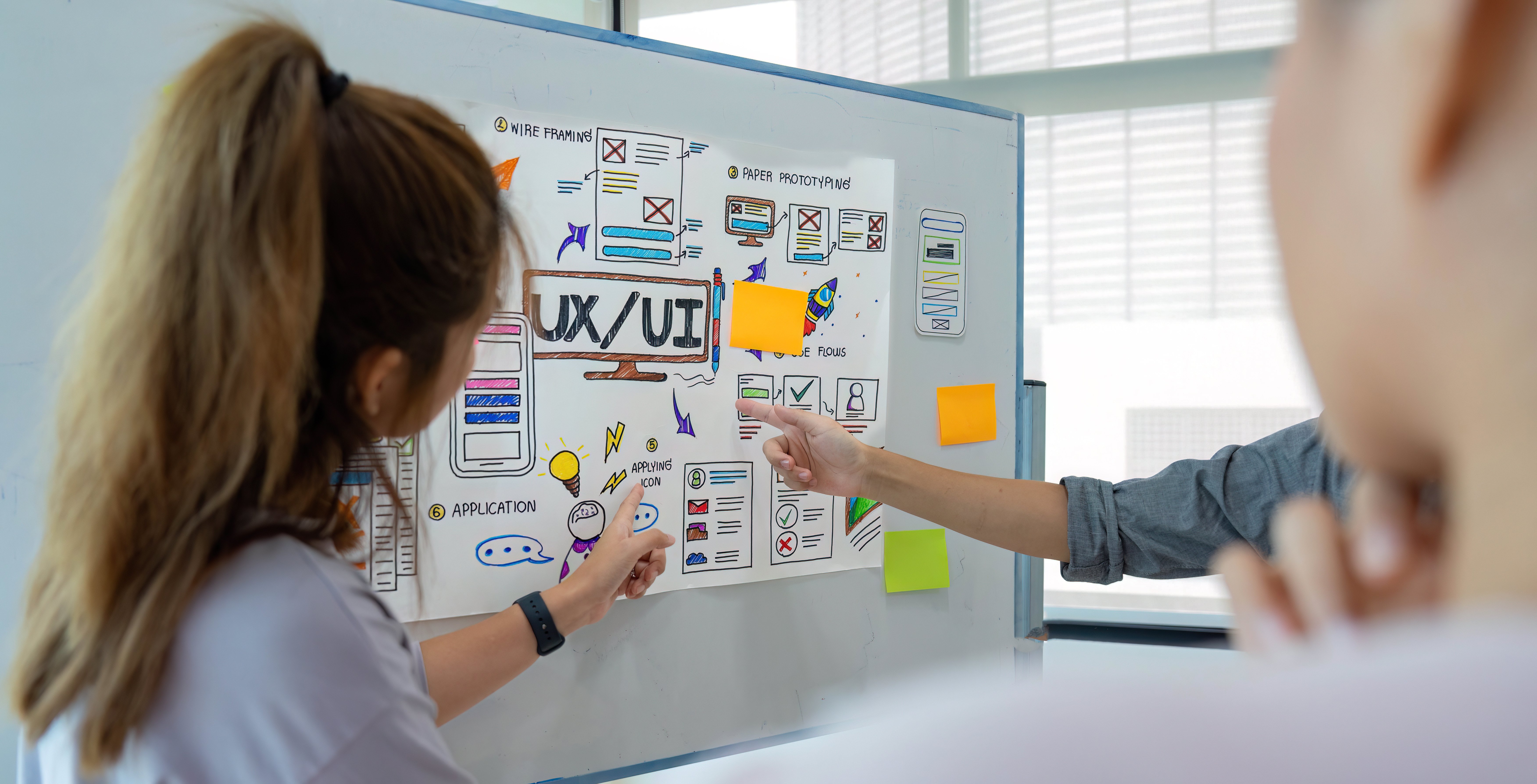 a-group-of-asian-start-ups-pointing-to-a-whiteboar-2023-11-27-05-33-50-utc