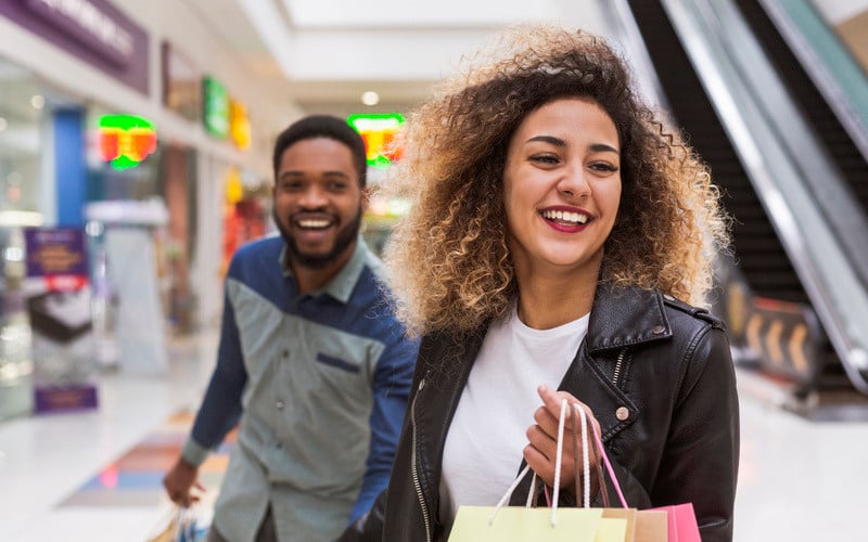 Couple smiles as they browse products on a shopping trip 